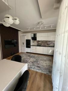 瓦尔纳Luxury Flat-4 People-Mladost的一间带桌子的客厅和一间厨房