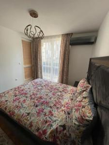 瓦尔纳Luxury Flat-4 People-Mladost的一间卧室配有一张带花卉床罩的大床