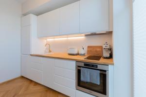 派尔努Cozy Stay Apartment的厨房配有白色橱柜和台面