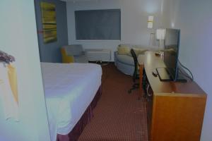 Van BurenVan Buren Inn的酒店客房配有一张床和一张书桌及一台电视
