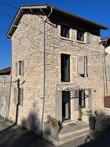 利勒达博La maison de Mounette的前面有两株盆栽植物的砖房