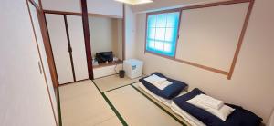 饭田市World Business Hotel的一间医院间,设有两张床和窗户