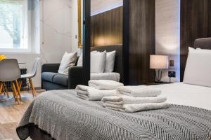 伦敦Circlelet Luxury Private Suite 3的一堆毛巾坐在房间里的床边