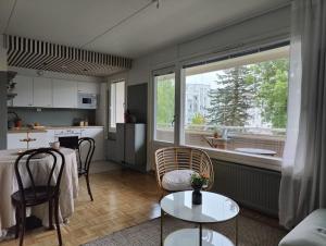 海门林纳Kodikas juuri remontoitu yksiö keskustassa的厨房以及带桌椅的起居室。