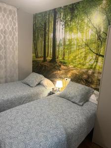 索里亚EL RAMILLETE的卧室内的两张床,带有森林壁画