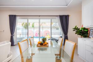 七岩Winter Home Villa Huahin的一间设有玻璃桌和椅子的用餐室