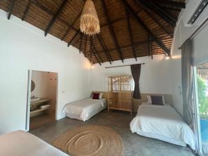 班泰Sarana Bungalows的一间卧室配有两张床和吊灯。