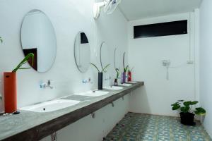 巴色ANOU HOSTEL的浴室设有一排盥洗盆和镜子
