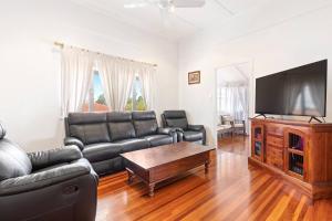UranganPrivate Resort-style Queenslander at Hervey Bay的客厅配有真皮沙发和平面电视