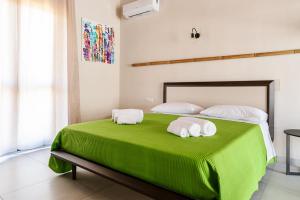 PeritoBorgo del Bambù的一间卧室配有绿床和毛巾