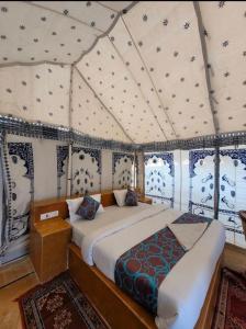 斋沙默尔Sam dunes desert safari camp的帐篷内一间卧室,配有一张床