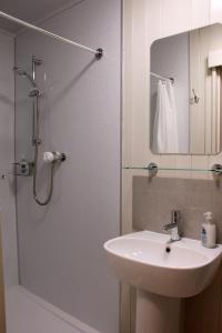 StrathdonSmithy Cottage的浴室配有盥洗盆和带镜子的淋浴