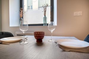 里摩日studio banc léger cœur de ville的一张木桌,上面放着两杯酒