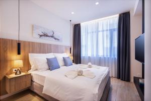 雅典Hestia - Romvis 9的卧室配有带蓝色枕头的大型白色床