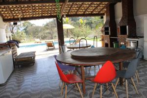 若阿诺波利斯Chalé Canto da Seriema的一个带游泳池的庭院里的一张木桌和椅子