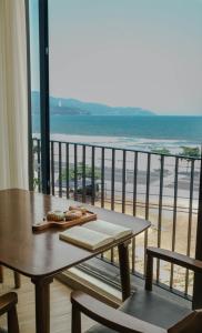 岘港Anstay Beach Da Nang的阳台配有桌子,享有海景。