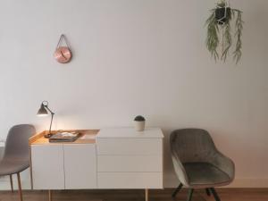 耶尔瑟克Yerseke Maarten & Hanh的一张带两把椅子和一盏灯的白色书桌