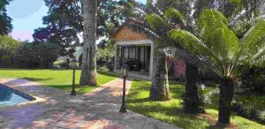希尔克雷斯特Matusadona Guest Lodge的棕榈树房屋和停车计