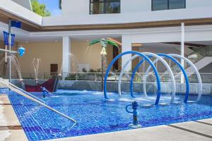 邦劳Best Western Plus The Ivywall Resort-Panglao的一个带蓝色喷泉的游泳池