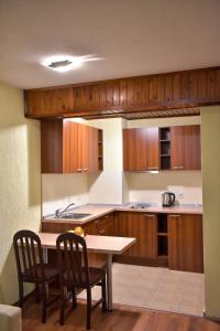 班斯科舒适公寓式酒店的厨房配有木制橱柜和桌椅