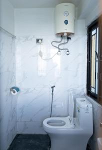 大吉岭Bastola Basthan Homestay的白色的浴室设有卫生间和窗户。