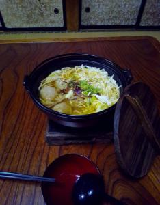 富士吉田市T&T Fujiyama Guest House的坐在桌子上一碗食物