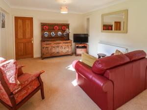WelbournHill Top Cottage的客厅配有红色沙发和电视