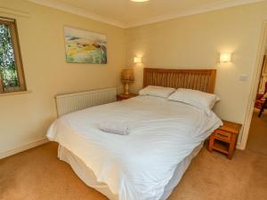 WelbournHill Top Cottage的卧室配有一张带白色床单和枕头的大床。