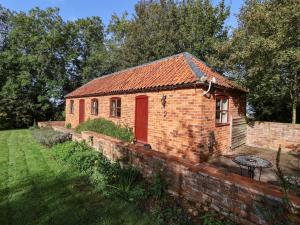 WelbournHill Top Cottage的院子里有红门的砖砌建筑