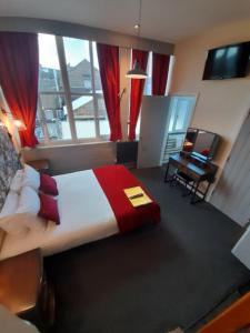 特伦特河畔斯托克Potbank的一间卧室配有一张床、一张书桌和一个窗户。