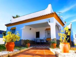 科尼尔-德拉弗龙特拉Chalet Piscina Privada Zona Vallada con Barbacoa的白色的房子,里面装有椅子和鲜花