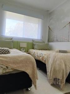 珀斯Simply delightful unit close to CBD and Beach的一间卧室设有两张床和窗户。
