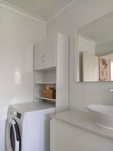 珀斯Simply delightful unit close to CBD and Beach的白色的浴室设有洗衣机和水槽。