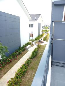 Bandar Puncak AlamIzz Homestay Near UITM Puncak Alam的一座带围栏和鲜花的房子的侧院