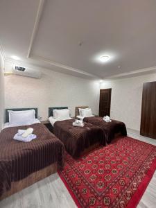 布哈拉Abuzar的酒店客房带两张床和红色地毯