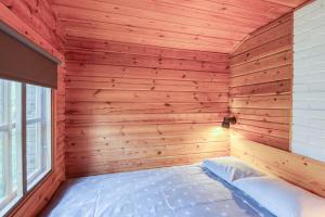 KalantiPinetree Cottages Cozy log cabin的一间位于角落的木制客房,配有一张床