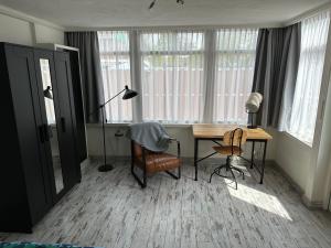 赞丹Zaandam Cottage Centre - Zaanse Schans Amsterdam的客房设有书桌、灯和椅子。