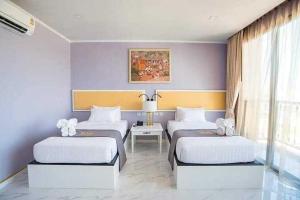 那空拍侬府Mekong Heritage Hotel的一间卧室配有两张床和一张桌子及一张桌子。