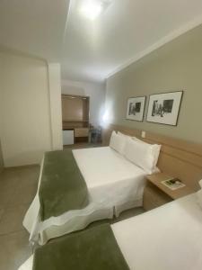 圣保罗上方酒店的卧室配有一张白色的大床和一张桌子