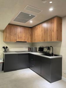阿拉木图AQ Capsule Hotel的厨房配有木制橱柜和黑色台面