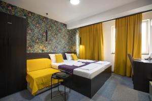 尼什四室公寓的一间卧室配有一张床和一张黄色的沙发