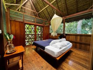 马尔多纳多港Hacienda Herrera Tambopata的一间设有床铺的卧室,位于带窗户的房间内