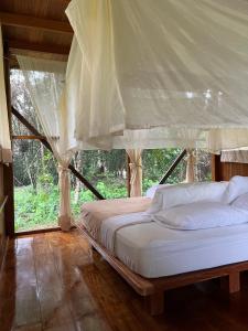 马尔多纳多港Hacienda Herrera Tambopata的一间卧室配有一张带天蓬的床