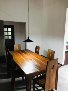 Sinharaja Cave Resort的木制用餐室配有椅子和安乐灯