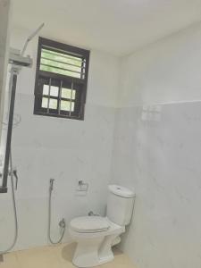 Sinharaja Cave Resort的白色的浴室设有卫生间和窗户。