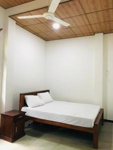 Sinharaja Cave Resort的配有吊扇的客房内的一张床位