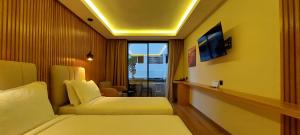 卡萨布兰卡Unico Hotel & Spa Casablanca的酒店客房设有两张床和电视。
