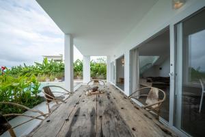 吉汶瓦OceanView Villa Manzini with Private Pool ZanzibarHouses的庭院里配有一张带椅子的大型木桌