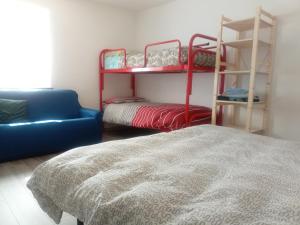 蓬泰巴Ostello Casa Morit的一间卧室配有一张床、一张沙发和双层床。