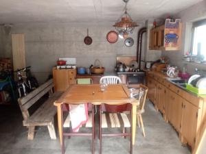 蓬泰巴Ostello Casa Morit的厨房配有木桌和椅子